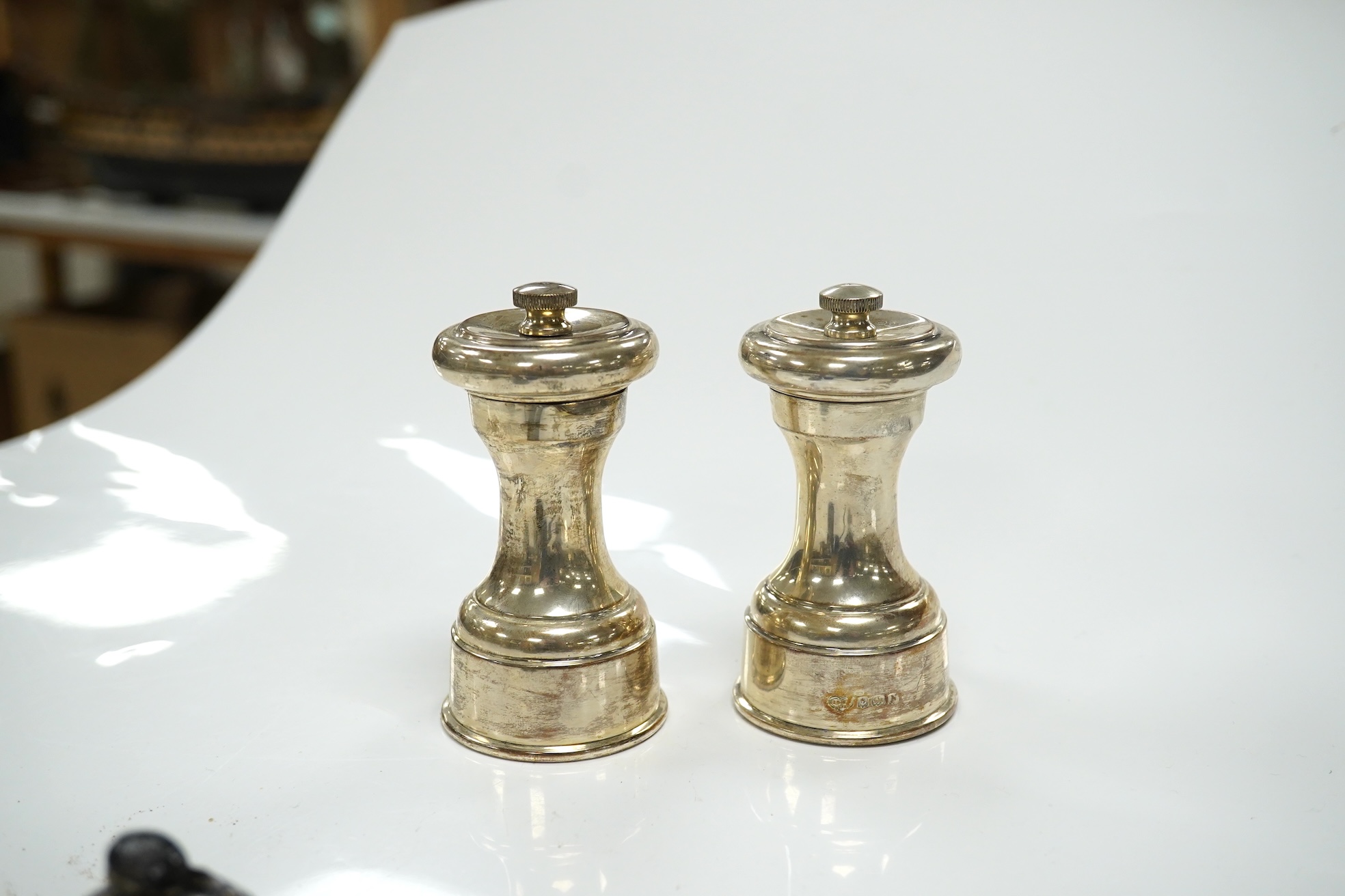 A 1930's four piece silver condiment set, a similar pair of peppermills and sundries. Condition - poor to fair